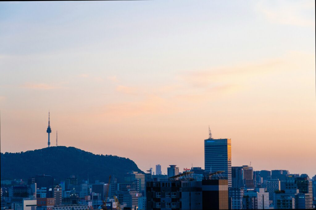 Namsan Tower standing tall above Seoul city skyline at sunset