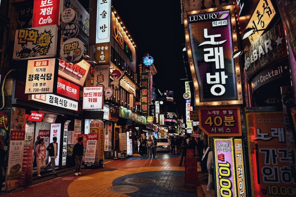 Neon lights illuminate a bustling street in korea.