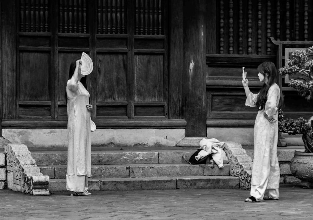 Two women in traditional dresses holding fans