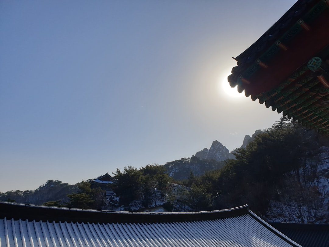 the sun is shining over a building in the mountains