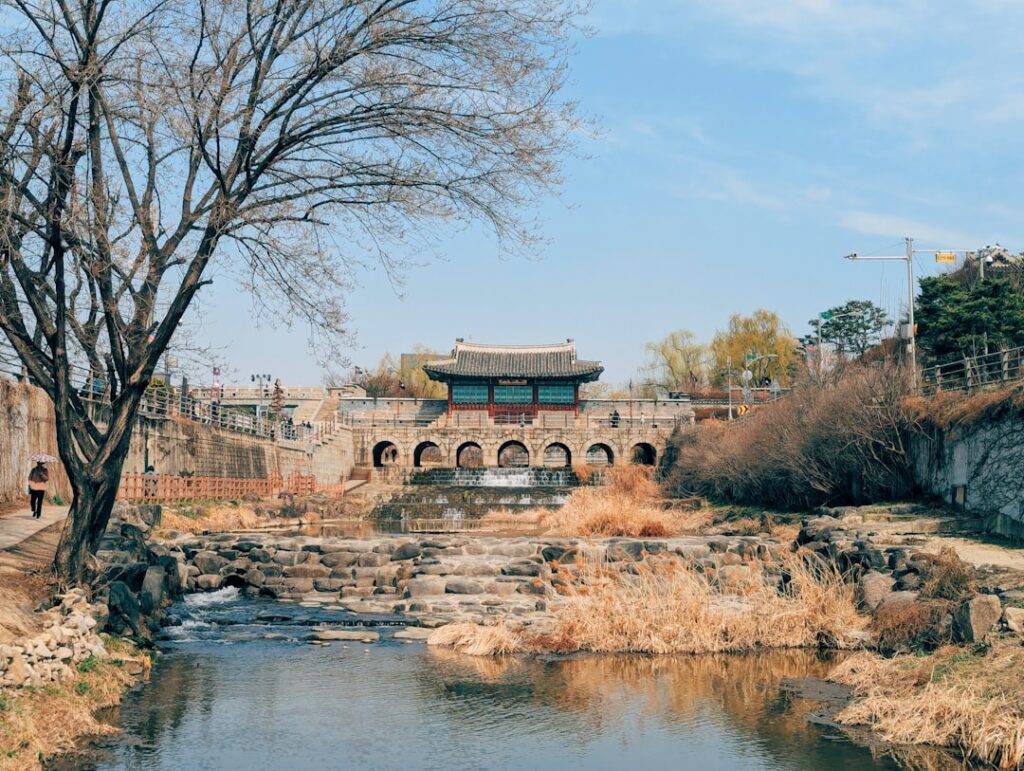 Historic korean gatehouse with arched entrance over water.