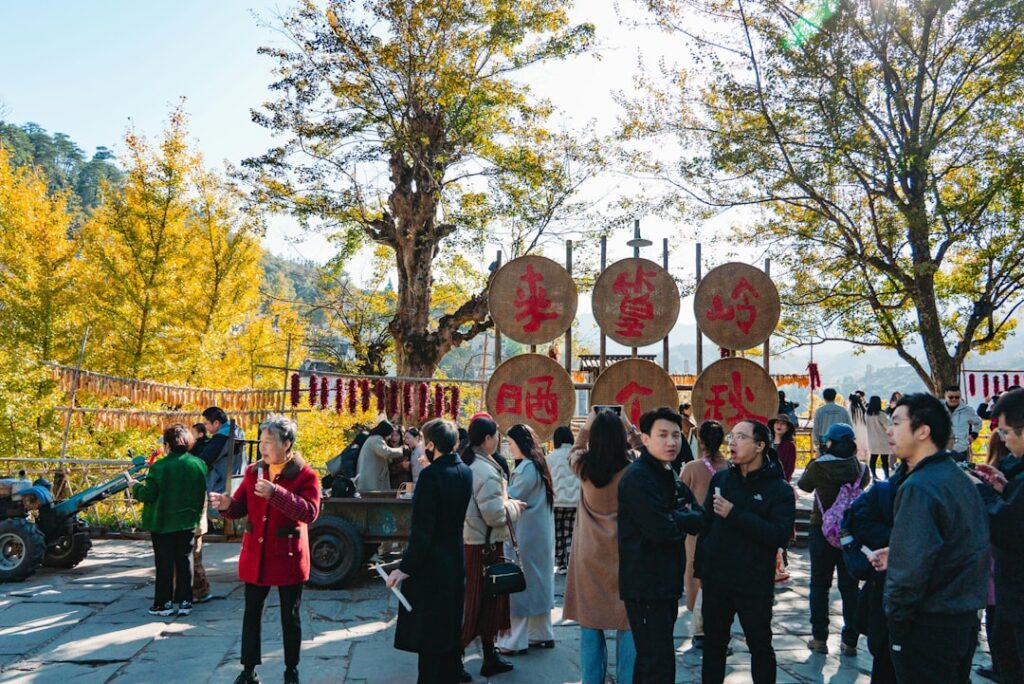 People gather near large decorative drums outdoors.