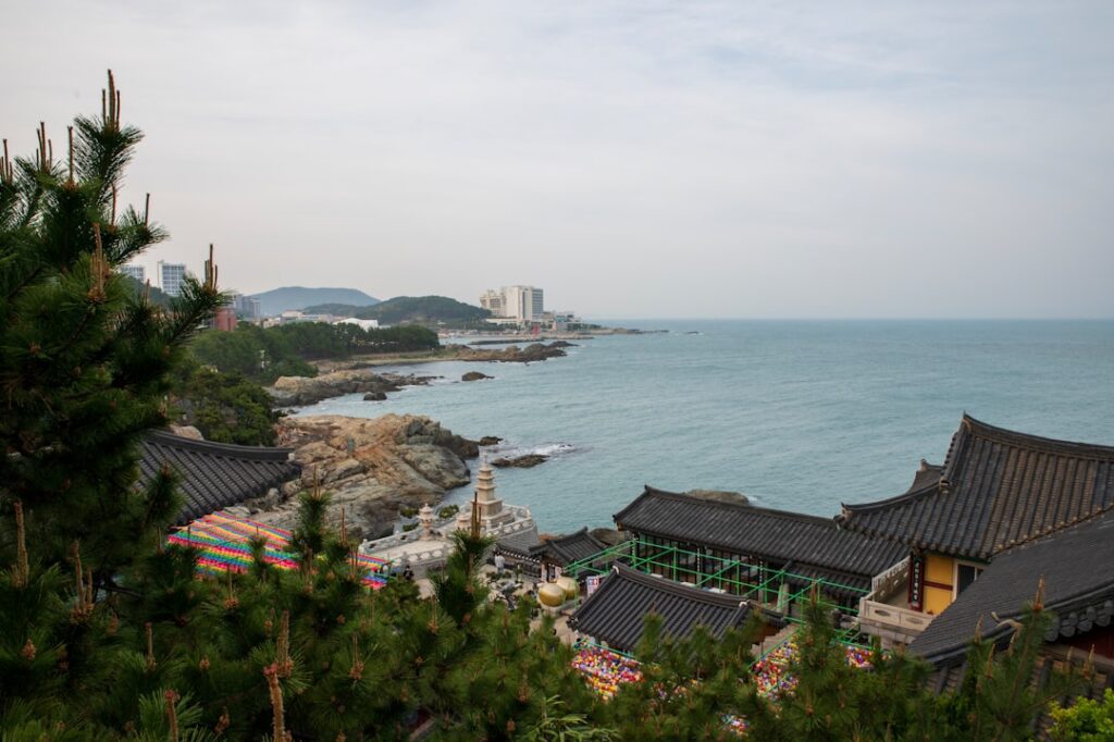 Coastal temple buildings overlooking the ocean with pine trees