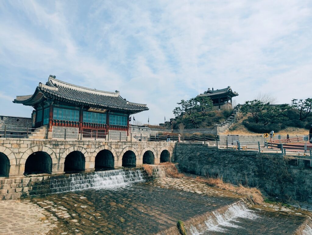 Historic korean fortress with arched bridge and flowing water