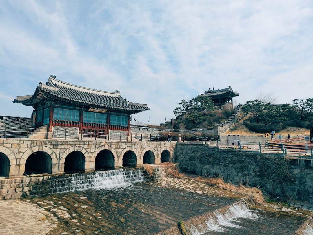 Historic korean fortress with arched bridge and flowing water